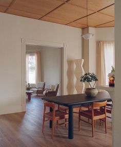 a dining room table with chairs and a potted plant on top of the table