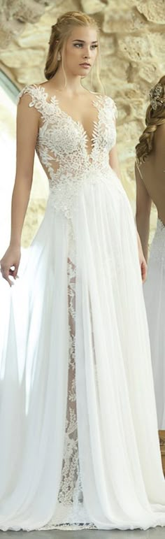 a woman in a wedding dress standing next to another woman