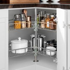 an open cabinet in the corner of a kitchen with spices and condiments on it