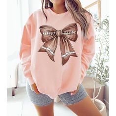 Add a touch of charm to game day with our Coquette Football Bow Sweatshirt! 🏈🎀 Celebrate your love for football with a stylish twist in this cozy sweatshirt, featuring a unique coquette bow design. Perfect for game days, tailgating, or any football event, this sweatshirt is a must-have for fans who love a blend of sporty and chic. 🌟 Charming Coquette Design: Our sweatshirt features a delightful football bow graphic, blending sporty vibes with a touch of elegance. The coquette bow adds a playf Cheerleading Tops For Fall, Casual Pink Sweatshirt For Game Day, Pink Long Sleeve Tops For Game Day, Pink Long Sleeve Sweatshirt For Game Day, Pink Long Sleeve Tops For Cheerleading, Cheer Sweater, Coquette Sweater, Football Event, Bow Sweatshirt