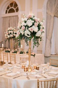 an elegant wedding reception with tall centerpieces