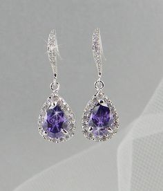 a pair of earrings with an amethorate and diamond set in the center