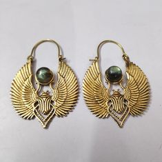 two pairs of gold toned earrings with green glass beads and an egyptian bird design on them