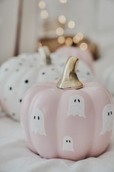 some pink pumpkins with ghost faces painted on them