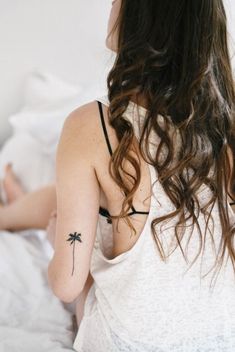 a woman with a small tattoo on her left arm and the back of her shoulder