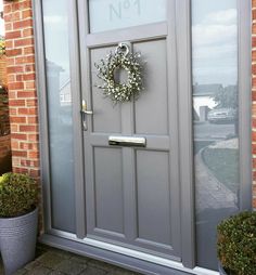 a grey front door with a wreath on it