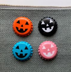 three bottle caps with jack o lantern faces on them