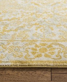 a yellow and white rug on top of a wooden floor next to a hardwood floor