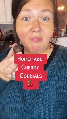 a woman holding up a sign that says homemade cherry cordials in front of her face