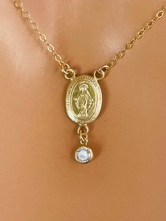 "This is a very sweet Miraculous medal charm necklace with a 4mm crystal bezel.  Such a simple yet lovely little necklace she is sure to love!  Mother Mary medallion and bezel are 14kt yellow gold filled, measures 15x10mm and comes on a 14kt yellow gold filled shiny cable chain. Necklace may be ordered in a 16\", 18\", 20 or 22\" length.   Necklace comes with a spring clasp in back.   Also available in 925 sterling silver or 14k rose gold filled. Model is wearing a 16\" length." Dainty Charm Necklaces With Miraculous Medal For Gifts, Dainty Charm Necklaces With Miraculous Medal As Gift, Dainty Miraculous Medal Charm Necklaces As Gifts, Dainty Miraculous Medal Charm Necklace As Gift, Anniversary Necklace With Miraculous Medal Pendant, Anniversary Necklace With Miraculous Medal, Miraculous Medal Necklace For Anniversary, 14k Gold Miraculous Medal Necklace For Anniversary, 14k Gold Necklace With Miraculous Medal For Anniversary