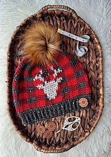 a red and black knitted hat sitting on top of a basket