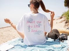 Embrace coastal charm with our vintage inspired seashells Comfort Colors cotton Tshirt. This Cottagecore aesthetic nautical Tee is perfect as an ocean swimsuit coverup or an coastal vacation surf shirt. Featuring a hand drawn textured feel to the text and seashells, this versatile Summer Vacation Mode Beach Shirt is ideal for any sunny adventure. Crafted from soft, breathable cotton, it's a must-have for your summer wardrobe :) Features a front and back design Available colors are: White Ivory B Nautical Short Sleeve Beach Top, Nautical Beach Tops For Summer, Nautical Style Beach Tops For Summer, Nautical Tops For Beach In Summer, Nautical Style Summer T-shirt With Letter Print, Nautical Cotton Tops For The Beach, Nautical Style Letter Print T-shirt For Summer, Nautical Letter Print T-shirt For Summer, Nautical Style Graphic Print Tops For Summer