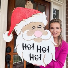 a woman standing in front of a door holding up a sign that says ho hoo