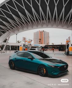 a blue car parked in front of a gas station