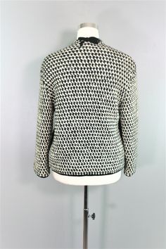 "Just one look, and you can see that this little knit blazer/jacket is minimally , but so tastefully styled. It is black and white with a black velvet trim and is lined in a red jersey. There is a bow sitting on the nape of the neck. Pair with a black slacks/sheath/ or even jeans. Estimated size S 38\" bust 38\" waist 16\" shoulder to shoulder 17\" sleeve 23\" nape to hem Purveyor's Note: We have searched far and wide, wrestled bears, braved the cold, traversed mountain ranges, fought pirates, s Spring Workwear Outerwear With Textured Knit, Spring Workwear Textured Knit Outerwear, Spring Textured Knit Outerwear For Work, Knit Turtleneck Outerwear For Workwear, Wool Turtleneck Outerwear With Textured Knit, Spring Turtleneck Cardigan For Workwear, Knitted Turtleneck Outerwear For Work, Knit Outerwear For Workwear In Fall, Fitted Textured Knit Elegant Outerwear