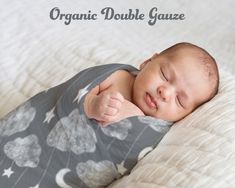 a baby sleeping on top of a bed with the words organic double gauze above it