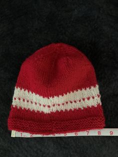 Beautiful red and white winter stocking cap. Hand knit with a wool mix yarn so it will keep your head warm and toasty on cold winter days. This stocking cap has quite a bit of stretch and will comfortably fit most people. Red Winter Beanie One Size Fits Most, Red Winter Beanie, One Size Fits Most, Warm Red Winter Hat, Casual Warm Red Beanie, Red Knitted Beanie For Winter, Red Knitted Winter Beanie, Casual Beanie Christmas Hats, Warm Red Hat, One Size Fits Most, Casual Christmas Beanie Hat