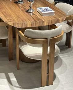 a wooden table with chairs around it and a book on top of the table next to it