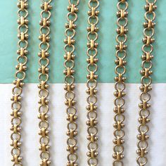 four different types of metal chains on a blue and white tablecloth with the same chain attached to each other