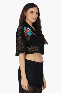 Made in cotton mesh Cropped half sleeves Black crochet mesh design Lapel collar Button-down shirt Relaxed fit Colorful hand embroidery detail in front Meet the Maison Black Embroidered Shirt, a game-changing fusion of bohemian sophistication and modern style!This cropped half-sleeve stunner is crafted from 100% cotton and showcases an intricate black crochet net design that's nothing short of mesmerizing. The vibrant blue floral embroidery, complete with whimsical butterflies, adds a pop of colo Embroidered Half Sleeve Top For Summer, Fitted Black Embroidered Top For Summer, Spring Beach Mesh Top With Short Sleeves, Summer Embroidered Tops With 3/4 Sleeves, Black Long Sleeve Embroidered Top, Black Long Sleeve Embroidered Top For Summer, Black Embroidered Long Sleeve Top For Summer, Black Embroidered V-neck Top For Summer, Summer Tops With Floral Embroidery And 3/4 Sleeve