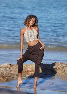 a woman is standing on the beach with her legs spread out in front of her