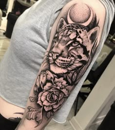 a woman's arm with a tiger and roses tattoo on her left arm, in black and white