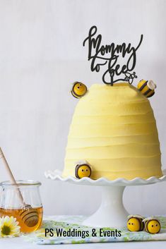 there is a yellow cake with bees on it and honey in the bowl next to it