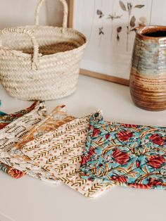 several pieces of cloth sitting on top of a table next to a basket and vase