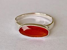 Sterling silver & carnelian ring  Carnelian oval faceted gemstone bezel set in sterling silver Highest quality 925 sterling silver (92.5% pure silver) & carnelian No two pieces of natural stone are identical. Colour variations and markings in the natural stones makes this a truly unique piece Specifications:    Color: Silver & Orange / Red   Material: 925 Sterling Silver & Carnelian Dimensions of gemstone: 14 mm x 6 mm approximately Weight of ring: 2.3 grams approximately Package Includes: 1 x Sterling silver & gemstone ring with complimentary jewellery pouch Carnelian Ring, Silver Jewelry Rings, Faceted Gemstones, Jewelry Creation, Jewelry Pouch, Gemstone Ring, Sterling Ring, Semi Precious Gemstones, Solid 925 Sterling Silver