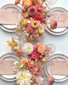 the table is set with plates, silverware and colorful flowers on top of each plate