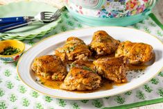 some food is sitting on a white plate and next to a crock pot with green napkins