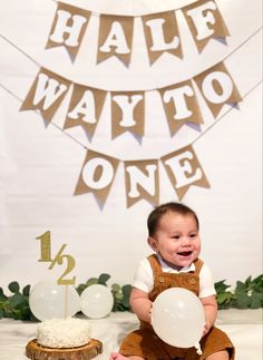 a baby is sitting on the floor in front of a cake