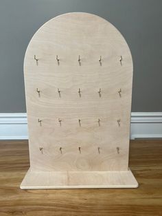 a wooden stand with several pegs on the top and two holes in the middle