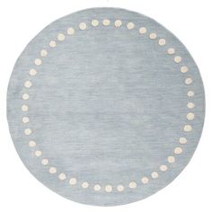 a round rug with white dots on it in light blue and beige colors, isolated against a white background