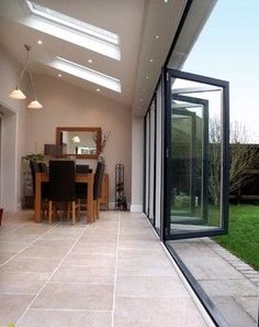 a dining room and kitchen area with skylights on the roof, grass in the background