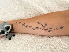 a raccoon tattoo on the leg of a woman