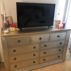 a flat screen tv sitting on top of a dresser