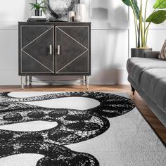 a black and white area rug in a living room with a couch, chair and sideboard