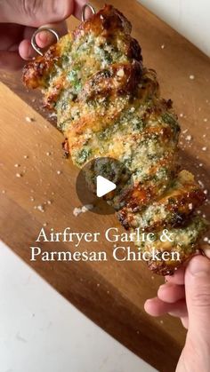 someone is holding up some food on a cutting board with the words air fryer garlic and parmesan chicken