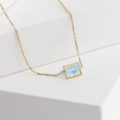 Description 10k yellow gold triangle aquamarine necklace, set in Januka's proprietary band setting. This beautiful light blue aquamarine sparkles like a lake's surface on a sunny day. Dainty and sophisticated for any occasions, whether it is business or casual. This necklace has a silicon adjuster at the back which allows you to shorten it to the length you desire to fit your look of the day.Band collection from Januka uses their proprietary setting method which tactfully carves each stone, so t Fine Jewelry Aquamarine Light Blue Necklace, Fine Jewelry Light Blue Aquamarine Necklace, Light Blue Aquamarine Necklace Fine Jewelry, Formal Light Blue Aquamarine Necklace, Aquamarine Light Blue Necklace For Anniversary, Yellow Gold Aquamarine Birthstone Necklace, Yellow Gold Blue Topaz Necklaces With Diamond Cut, Formal Yellow Gold Aquamarine Necklace, Light Blue 14k Gold Formal Jewelry