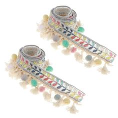 pair of multicolored beaded bracelets with tassels on white background