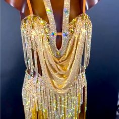 the back of a woman's dress with gold sequins and beads on it