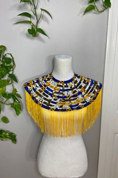 This handmade Web collar / bib / necklace is true statement piece.  Looks great worn over a solid colored outfit or under the collar of a crisp white shirt. The marigold fringe is the icing on top of the cake!  The necklace fastens in the back with a pretty button. Neck opening is approx 17.5 inches, one size fits most.  May be worn with button in the back, on shoulder, or in front. Either way, this necklace is a bonafide conversation stater! Yellow Ankara, Leather Statement Necklace, Gold Bib Necklace, Collar Shirts Women, Shoulder Necklace, African Outfits, African Crafts, African Accessories, Unique Bridesmaid