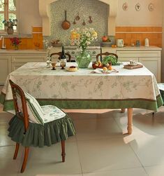 a kitchen with a table and chairs in front of an oven, potted plant on the stove