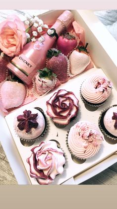 a box filled with lots of cupcakes covered in pink frosting and flowers