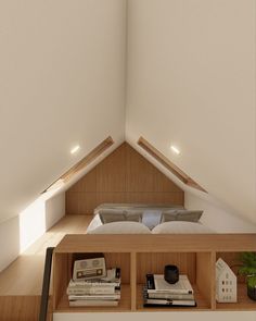 an attic bedroom with white walls and wooden furniture, along with bookshelves on the floor