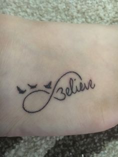 a foot with a tattoo that says believe on the side and birds flying around it