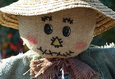 a scarecrow doll wearing a straw hat and scarf