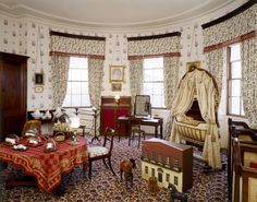 a living room filled with furniture and lots of windows next to a table covered in red cloths