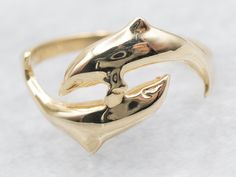 Crafted with detail, this bypass ring features two playful dolphins swimming gracefully around your finger. Made with yellow gold, this ring is a symbol of grace and beauty. Perfect for any occasion, it is a must-have for any fashion-forward individual! Metal: 14K Yellow Gold Ring Size: 6 Marks: "14K DZ" Stamped on the inside band SKU #: A48527 Each piece has been identified and graded by a Graduate Gemologist who has been certified by the Gemological Institute of America (GIA). We have six brick-and-mortar storefronts in Maine, Massachusetts, and New Hampshire and have been in business for over 25 years! Please visit our Shop's About Page or our website for more information about our jewelry. For questions about diamond grading, we recommend the  Gemological Institute of America (GIA), th Dolphins Swimming, Dolphin Ring, Grace Symbol, Animal Ring, Bypass Ring, Animal Rings, Yellow Gold Ring, Ring Gold, New Hampshire